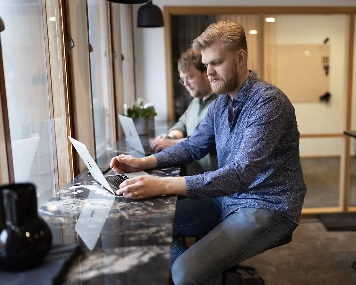 Två utvecklare programmerar vid fönstret